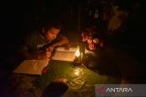 Seorang anak belajar dengan menggunakan lampu petromaks sebagai alat bantu penerangan di Medan, Sumatera Utara, Rabu (5/6/2024). Pemadam listrik tersebut terjadi sejak Selasa (4/6)  dikarenakan adanya gangguan pada Transmisi Saluran Udara Tegangan Ekstra Tinggi (SUTT) 275 kV Linggau-Lahat, Sumatera Selatan. ANTARA FOTO/Fransisco Carolio