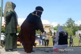 Algojo melakukan eksekusi cambuk terhadap terpidana pelanggaran Qanun Syariat Islam (kanan) di halaman Masjid Agung Al-Munawarah Kecamatan Kota Jantho, kabupaten Aceh Besar, Aceh, Jumat (7/6/2024). Mahkamah Syariah di Daerah itu menjatuhkan hukuman 2 hingga 6 kali cambuk setelah dipotong masa tahanan terhadap tiga terpidana pelanggaran syariat dalam kasus judi (maisir)  dan kasus berduaan laki dan perempuan di tempit sepi bukan mahramnya (khalwat))  sedangkan seorang terpidana oknum polisi bersama pasangan wanitanya  terkait kasus khalwat  tidak hadir menjalani hukuman cambuk  karena alasan sakit. ANTARA FOTO/Ampelsa.