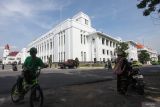 Warga mengamati Gedung Internatio di Jalan Garuda, Surabaya, Jawa Timur, Sabtu (8/6/2024). Pemerintah Kota Surabaya mempercepat pengerjaan revitalisasi infrastruktur Kota Lama di kawasan itu yang ditargetkan akan diresmikan pada pertengahan bulan Juni 2024 menjadi salah satu destinasi wisata sejarah di Surabaya. Antara Jatim/Didik Suhartono/um 