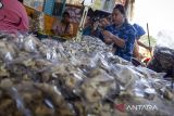 Pekerja membungkus kerupuk kulit ikan patin di Indramayu, Jawa Barat, Sabtu (8/6/2024). Kementerian Koperasi dan UKM menyatakan realisasi penyaluran Kredit Usaha Rakyat (KUR) untuk berbagai jenis pelaku usaha hingga Mei 2024 mencapai Rp116,94 triliun dari target penyaluran KUR sebesar Rp300 triliun. ANTARA FOTO/Dedhez Anggara/agr
