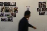 Pengunjung melihat foto yang dipajang dalam pameran foto cerita bertajuk 