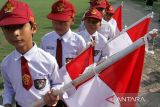 Penjabat Wali Kota Lhokseumawe A Hanan (kanan), Kapolres Lhokseumawe AKBP Henki Ismanto (kiri) membagikan Bendera Merah Putih kepada pelajar dalam apel Gerakan Pembagian 10 juta Bendera Merah Putih 2024 di Lhokseumawe, Aceh, Senin (10/6/2024). Kegiatan itu merupakan gerakan nasional yang digagas Kementerian Dalam Negeri untuk memeriahkan HUT ke-79 Kemerdekaan RI guna membangkitkan semangat nasionalisme serta kecintaan terhadap bangsa dan negara. ANTARA /Rahmad