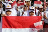 Penjabat Wali Kota Lhokseumawe A Hanan (kanan), Kapolres Lhokseumawe AKBP Henki Ismanto (kiri) membagikan Bendera Merah Putih kepada pelajar dalam apel Gerakan Pembagian 10 juta Bendera Merah Putih 2024 di Lhokseumawe, Aceh, Senin (10/6/2024). Kegiatan itu merupakan gerakan nasional yang digagas Kementerian Dalam Negeri untuk memeriahkan HUT ke-79 Kemerdekaan RI guna membangkitkan semangat nasionalisme serta kecintaan terhadap bangsa dan negara. ANTARA /Rahmad