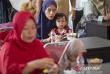 Orang tua mendampingi anak-anak menyantap makanan sehat di Balongan, Indramayu, Jawa Barat, Senin (10/6/2024). Pemerintah Kabupaten Indramayu menginisiasi gerakan makan bersama anak stunting untuk memberikan pemenuhan gizi bagi anak penderita stunting. ANTARA FOTO/Dedhez Anggara/agr