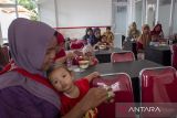 Orang tua bersama anak-anak menyantap makanan sehat di Balongan, Indramayu, Jawa Barat, Senin (10/6/2024). Pemerintah Kabupaten Indramayu menginisiasi gerakan makan bersama anak stunting untuk memberikan pemenuhan gizi bagi anak penderita stunting. ANTARA FOTO/Dedhez Anggara/agr
