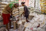 Pekerja menimbang beras di Toko Dewi Sri Utama, Kota Tasikmalaya, Jawa Barat, Senin (10/6/2024). Pemerintah menetapkan harga eceran tertinggi (HET) beras medium dan premium berdasarkan wilayah di antaranya Jawa, Lampung, dan Sumatera Selatan seharga Rp12.500 per kg untuk beras medium dan beras premium Rp14.900 per kg. ANTARA FOTO/Adeng Bustomi/agr