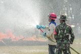 Petugas gabungan memadamkan api yang membakar lahan saat simulasi pemadaman kebakaran hutan dan lahan (karhutla) di lapangan sepak bola Universitas Jambi, Mendalo Darat, Muaro Jambi, Jambi, Rabu (12/6/2024). Simulasi yang melibatkan sejumlah pihak, di antaranya TNI/Polri, perguruan tinggi, pemerintah daerah dan swasta itu bertujuan memadukan koordinasi lintas sektor dalam mengantisipasi potensi terjadinya Karhutla saat kemarau di daerah itu. ANTARA FOTO/Wahdi Septiawan/YU