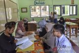 Guru memeriksa kelengkapan persyaratan calon peserta didik baru saat daftar ulang di SMA Negeri 1 Ciamis, Jawa Barat, Kamis (20/6/2024). Dinas Pendidikan Jawa Barat mengumumkan hasil Penerima Peserta Didik Baru (PPDB) dan membuka daftar ulang calon peserta didik baru 2024 dari hasil pendaftaran tahap 1 jalur zonasi dan afirmasi Keluarga Ekonomi Tidak Mampu (KETM) ekstrem dan normatif tingkat SMA dan SMK. ANTARA FOTO/Adeng Bustomi/agr