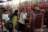 Pengunjung memilih kain tenun khas Bali saat Pameran Industri Kerajinan dalam rangkaian Pesta Kesenian Bali ke-46 di Taman Budaya Bali, Denpasar, Bali, Kamis (20/6/2024). Kegiatan itu diikuti ratusan pelaku industri kecil dan menengah untuk menggerakkan perekonomian masyarakat khususnya para perajin dari berbagai wilayah di Bali dengan mempromosikan berbagai produk kerajinan unggulan khas Bali itu kepada warga dan wisatawan. ANTARA FOTO/Fikri Yusuf/wsj.