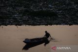 Warga menggunakan perahu untuk memancing di dekat tumpukan sampah yang telah dijaring di aliran Sungai Citarum, Kabupaten Bandung Barat, Jawa Barat, Jumat (21/6/2024). Pemerintah Jawa Barat menerapkan jaring penyekat sampah di sejumlah titik dari hulu hingga hilir di aliran Sungai Citarum sebagai salah satu pilihan dalam mengatasi dan mengantisipasi sampah yang terbawa arus ataupun mengendap di aliran sungai. ANTARA FOTO/Novrian Arbi/agr