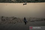 Warga menaiki perahu di dekat tumpukan sampah yang telah dijaring di aliran Sungai Citarum, Kabupaten Bandung Barat, Jawa Barat, Jumat (21/6/2024). Pemerintah Jawa Barat menerapkan jaring penyekat sampah di sejumlah titik dari hulu hingga hilir di aliran Sungai Citarum sebagai salah satu pilihan dalam mengatasi dan mengantisipasi sampah yang terbawa arus ataupun mengendap di aliran sungai. ANTARA FOTO/Novrian Arbi/agr