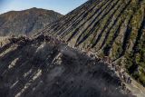 Foto udara masyarakat Suku Tengger merayakan Yadnya Kasada di kawah Gunung Bromo, Probolinggo, Jawa Timur, Sabtu (22/6/2024). Perayaan Yadnya Kasada merupakan bentuk ungkapan syukur dan penghormatan kepada leluhur masyarakat Suku Tengger dengan cara melarung sesaji berupa hasil bumi dan ternak ke kawah Gunung Bromo. Antara Jatim/Muhammad Mada/um