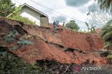 Warga mengamati lokasi jalan terdampak longsor di Pasirjati, Cijengkol, Caringin, Kabupaten Sukabumi, Jawa Barat, Rabu (26/6/2024). Intensitas hujan yang tinggi mengakibatkan jalan penghubung antarkecamatan Caringin dan Cibadak longsor sedalam 10 meter sehingga menyebabkan akses jalan terputus. ANTARA FOTO/Henry Purba/agr
