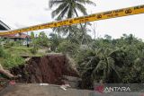 Warga melihat lokasi jalan longsor di Pasirjati, Cijengkol, Caringin, Kabupaten Sukabumi, Jawa Barat, Rabu (26/6/2024). Intensitas hujan yang tinggi mengakibatkan jalan penghubung antarkecamatan Caringin dan Cibadak longsor sedalam 10 meter sehingga menyebabkan akses jalan terputus. ANTARA FOTO/Henry Purba/agr
