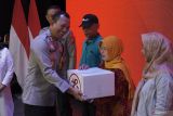 Kapolres Lumajang AKBP Mohammad Zainur Rofik (kiri) memberikan paket bantuan sosial saat gelaran bakti kesehatan dan bakti sosial dalam rangka HUT ke-78 Bhayangkara di Gedung Rock Convention Center (RCC), Lumajang, Jawa Timur, Rabu (26/6/2024). Dalam kegiatan tersebut, sekitar 1.500 masyarakat kurang mampu mendapatkan bansos dan 12 pelayanan kesehatan gratis yang digelar oleh Polda Jawa Timur dengan melibatkan 120 tenaga kesehatan. ANTARA Jatim/Irfan Sumanjaya/mas.