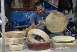 Seorang perajin yang juga seniman menabuh alat musik tradisional Rapai seusai pembuatan di desa  Kaye Lheu, kecamatan Ingin Jaya, kabupaten Aceh Besar, Aceh, Sabtu (29/6/2024). Pembuatan alat musik Rapai yang sudah masuk warisan budaya tak benda terbuat dari bahan kayu dan kulit kambing yang diciptakan oleh Syech Rapai pada  abad ke-11 di Aceh  tersebut,  dalam beberapa tahun terakhir produksinya masih tergantung pesanan dengan harga kisaran Rp300.000 per unit tergantung pada ukuran diameter dan kualitas bahan baku gendang Rapai. ANTARA FOTO/Ampelsa.