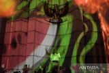 Seniman menampilkan seni tari dalam aksi video mapping dukungan untuk palestina yang divisualkan di Monumen Perjuangan Rakyat Jawa Barat, Bandung, Jawa Barat, Sabtu (29/6/2024). Aksi yang diinisiasi oleh Sembilan Matahari dan Bandung Creative City Forum tersebut merupakan seni intervensi di ruang publik untuk terus berkampanye dan meningkatkan kesadaran generasi muda dalam menolak kejahatan kemanusiaan serta penjajahan yang terjadi di Palestina. ANTARA FOTO/Novrian Arbi/agr