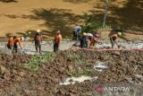 Petugas BPBD Kabupaten Tasikmalaya dan relawan membersihkan material tanah longsor yang menimbun jalan penghubung antarkecamatan di Desa Nangtang, Kabupaten Tasikmalaya, Jawa Barat, Minggu (30/6/2024). BPBD Kabupaten Tasikmalaya mencatat sebanyak 17 titik di tujuh kecamatan Kabupaten Tasikmalaya mengalami bencana alam yakni longsor dan banjir. ANTARA FOTO/Adeng Bustomi/agr
