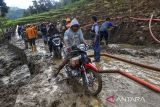 Petugas BPBD Kabupaten Tasikmalaya dan relawan membersihkan material tanah longsor yang menimbun jalan penghubung antarkecamatan di Desa Nangtang, Kabupaten Tasikmalaya, Jawa Barat, Minggu (30/6/2024). BPBD Kabupaten Tasikmalaya mencatat sebanyak 17 titik di tujuh kecamatan Kabupaten Tasikmalaya mengalami bencana alam yakni longsor dan banjir. ANTARA FOTO/Adeng Bustomi/agr