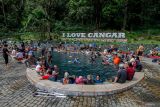 Sejumlah pengunjung berendam di pemandian air panas Cangar, Batu, Jawa Timur, Minggu (30/6/2024). Destinasi wisata yang terletak di kawasan Taman Hutan Raya Raden Soerjo itu kini telah selesai direnovasi oleh Pemerintah setempat sehingga target kunjungan wisatawan 2024 sebanyak 12 juta orang di kawasan wisata unggulan Jawa Timur tersebut diharapkan dapat tercapai. Antara Jatim/Muhammad Mada/um 