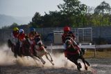 Joki memacu kudanya saat mengikuti kejuaraan pacuan kuda di Ponorogo, Jawa Timur, Minggu (30/6/2024). Kejuaraan yang yang memperlombakan 10 kelas dengan jarak antara 1.000 meter hingga 1.600 meter tersebut diikuti 100 kuda dari berbagai daerah di Jawa dan Bali. Antara Jatim/Siswowidodo/um