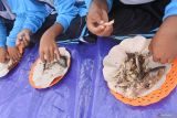 Sejumlah siswa mengikuti lomba memakan ikan tongkol (Euthynnus affinis) dalam Fishing Camp 2024 di Pantai Sijile, Desa Sumberwaru, Banyuputih, Situbondo, Jawa Timur, Minggu (30/6/2024). Melalui lomba itu anak-anak diajak gemar makan ikan laut sebagai penunjang gizi. Antara Jatim/Seno/um 