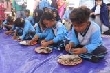 Sejumlah siswa mengikuti lomba memakan ikan tongkol (Euthynnus affinis) dalam Fishing Camp 2024 di Pantai Sijile, Desa Sumberwaru, Banyuputih, Situbondo, Jawa Timur, Minggu (30/6/2024). Melalui lomba itu anak-anak diajak gemar makan ikan laut sebagai penunjang gizi. Antara Jatim/Seno/um 