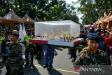 Anggota Brimob Polda Jabar membawa nasi tumpeng saat Festival HUT Bhayangkara yang digelar di Bandung, Jawa Barat, Senin (1/7/2024). Pemerintah Provinsi Jawa Barat bersama Polda Jabar menggelar Festival HUT ke-78 Bhayangkara yang menampilkan tarian kebudayaan khas Jawa Barat serta iring-iringan kendaraan tempur dan komunitas kendaraan yang ada di Kota Bandung. ANTARA FOTO/Raisan Al Farisi /agr