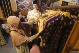 Pengunjung memilih baju batik pada stand pameran Karya Kreatif Mataraman di Kota Kediri, Jawa Timur, Minggu (30/6/2024). Pameran yang diselenggarakan Bank Indonesia tersebut menampilkan produk-produk unggulan usaha mikro kecil menengah (UMKM) dari 13 kota/kabupaten sebagai upaya mendorong pertumbuhan ekonomi daerah. ANTARA Jatim/Prasetia Fauzani/mas.