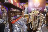 Petugas menjaga stand pameran batik pada kegiatan Karya Kreatif Mataraman di Kota Kediri, Jawa Timur, Minggu (30/6/2024). Pameran yang diselenggarakan Bank Indonesia tersebut menampilkan produk-produk unggulan usaha mikro kecil menengah (UMKM) dari 13 kota/kabupaten sebagai upaya mendorong pertumbuhan ekonomi daerah. ANTARA Jatim/Prasetia Fauzani/mas.