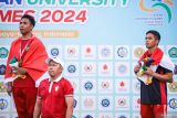 Pelari Indonesia Lalu Muhammad Zohri (kiri) dan Jaelani Fatah Sidik (kanan) menyanyikan lagu Indonesia Raya saat penyerahan medali seusai final 100 meter putra ASEAN University Games (AUG) 2024 di Lapangan Atletik UNESA, Surabaya, Jawa Timur, Selasa (2/7/2024). Zohri dan Fatah meraih medali emas dan perunggu dengan catatan waktu 10,19 detik dan 10,59 detik. Antara Jatim/Rizal Hanafi/um