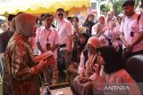 Menteri Sosial Tri Rismaharini (kiri) berbicang dengan penulis muda berkebutuhan khusus keluarga penerima manfaat Program Keluarga Harapan (PKH) saat penyaluran bantuan program Atensi Kewirausahaan Warindo di Bale Kota Tasikmalaya, Jawa Barat, Rabu (3/7/2024). Mensos menyalurkan bantuan modal usaha 50 gerobak kepada keluarga penerima manfaat PKH di Kota dan Kabupaten Tasikmalaya untuk meningkatkan taraf ekonomi masyarakat. ANTARA FOTO/Adeng Bustomi/agr