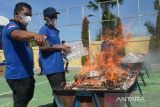 Petugas Bea Cukai bersama instansi terkait lainnya membakar rokok impor ilegal hasil  penindakan operasi gabungan saat pemusnahan  di Banda Aceh, Aceh, Rabu (3/7/2024). Kanwil Bea Cukai Aceh memusnahkan sebanyak 5.910.000 batang rokok impor ilegal  dan menangkap empat tersangka serta satu unit barang bukti kapal penyelundup KM Indah Dua GT.45 QQB  No.172  dengan perkiraan kerugian negara Rp 18,625 miliar.  ANTARA FOTO/Ampelsa.