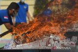 Petugas Bea Cukai bersama instansi terkait lainnya membakar rokok impor ilegal hasil  penindakan operasi gabungan saat pemusnahan  di Banda Aceh, Aceh, Rabu (3/7/2024). Kanwil Bea Cukai Aceh memusnahkan sebanyak 5.910.000 batang rokok impor ilegal  dan menangkap empat tersangka serta satu unit barang bukti kapal penyelundup KM Indah Dua GT.45 QQB  No.172  dengan perkiraan kerugian negara Rp 18,625 miliar.  ANTARA FOTO/Ampelsa.