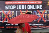 Warga berjalan di depan spanduk sosialisasi larangan judi online di Kantor Kecamatan Bogor Selatan, Kota Bogor, Jawa Barat, Senin (1/7/2024). Spanduk tersebut dipasang di sejumlah titik jalan dan kelurahan di wilayah Kecamatan Bogor Selatan karena berdasarkan data Pusat Pelaporan dan Analisis Transaksi Keuangan (PPATK) menyebutkan bahwa di kecamatan tersebut tercatat menjadi wilayah dengan nilai total transaksi judi online paling tinggi di Indonesia dengan pelaku judi online mencapai 3.720 orang dan perputaran uang sebanyak Rp349 miliar. ANTARA FOTO/Arif Firmansyah/YU

