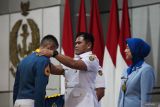 Kepala Staf TNI Angkatan Laut (KSAL) Laksamana TNI Muhammad Ali (tengah) mengalungkan lencana kelulusan pada salah satu Taruna Akademi Angkatan Laut (AAL) saat Penutupan Pendidikan (Tupdik) dan Wisuda Sarjana Taruna Akademi TNI Angkatan Laut Angkatan ke-69 Tahun 2024 di Gedung Maspardi, AAL, Bumimoro, Surabaya, Jawa Timur, Jumat (5/7/2024). Akademi Angkatan Laut (AAL) mewisuda 129 Taruna AAL Angkatan ke-69, yang terdiri dari 58 orang Korps Pelaut, 21 orang Korps Teknik, 21 orang Korps Elektronika, 16 orang Korps Suplai dan 13 orang Korps Marinir. Antara Jatim/Didik Suhartono/um 