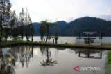 Sejumlah pengunjung menikmati keindahan Danau Law Kawar di Desa Kutagugung, Kecamatan Naman Teran, Kabupaten Karo, Sumatera Utara, Sabtu (6/7/2024). Wisata Danau Law Kawar yang memiliki luas 200 hektare tersebut merupakan wisata legenda yang menceritakan sebuah desa yang tenggelam akibat kutukan seorang nenek yang merasa sakit hati kepada anak dan cucu yang telah memberikan makan sisa dari acara adat masyarakat Karo. ANTARA FOTO/Yudi Manar