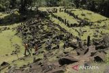 Pengunjung melintas di antara bebatuan di situs Gunung Padang, Campaka, Kabupaten Cianjur, Jawa Barat, Minggu (7/7/2024). Situs megalitik berbentuk punden berundak yang ditemukan pada tahun 1914 tersebut menjadi salah satu objek wisata andalan di Cianjur yang menarik bagi wisatawan dan peneliti sejarah. ANTARA FOTO/Henry Purba/agr
