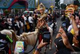 Peserta menyapa penonton saat mengikuti Kirab Budaya Lintas Sejarah di Kabupaten Ponorogo, Jawa Timur, Sabtu (6/7/2024). Kirab budaya dalam rangka menyambut datangnya tahun baru Hijriyah 1 Muharam bersamaan 1 Sura dalam penanggalan Jawa tersebut diikuti ribuan peserta terdiri pejabat daerah, perwakilan kantor pemerintah, sekolah, swasta, dan masyarakat umum. Antara Jatim/Siswowidodo/mas.