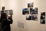 Warga memotret foto pada pameran fotografi bertema Zona Cerita di Galeri Dewan Kesenian Surabaya, komplek Balai Pemuda Surabaya, Jawa Timur, Selasa (9/7/2024). Pameran foto cerita itu menampilkan delapan foto cerita karya tujuh fotografer dari Communication Photography Club (CIPHOC) dan berlangsung hingga 13 Juli 2024. Antara Jatim/Didik Suhartono/um 