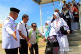 Penjabat Gubernur Kalimantan Barat Harisson (kiri) menyambut kedatangan Jamaah Haji asal Kalimantan Barat turun dari pesawat di Bandara Supadio, Kabupaten Kubu Raya, Kalimantan Barat, Rabu (10/7/2024). Sebanyak 181 jamaah haji asal Kabupaten Sambas, Landak dan Bengkayang embarkasi Batam yang tergabung dalam kloter 16 tiba di Kalimantan Barat usai menunaikan ibadah haji di Tanah Suci Mekkah. ANTARA FOTO/Jessica Wuysang