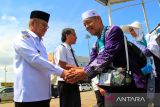 Penjabat Gubernur Kalimantan Barat Harisson (kiri) menyambut kedatangan Jamaah Haji asal Kalimantan Barat turun dari pesawat di Bandara Supadio, Kabupaten Kubu Raya, Kalimantan Barat, Rabu (10/7/2024). Sebanyak 181 jamaah haji asal Kabupaten Sambas, Landak dan Bengkayang embarkasi Batam yang tergabung dalam kloter 16 tiba di Kalimantan Barat usai menunaikan ibadah haji di Tanah Suci Mekkah. ANTARA FOTO/Jessica Wuysang