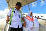 Seorang jamaah haji lansia asal Kalimantan Barat dituntun petugas Pemprov Kalbar saat menuruni tangga pesawat di Bandara Supadio, Kabupaten Kubu Raya, Kalimantan Barat, Rabu (10/7/2024). Sebanyak 181 jamaah haji asal Kabupaten Sambas, Landak dan Bengkayang embarkasi Batam yang tergabung dalam kloter 16 tiba di Kalimantan Barat usai menunaikan ibadah haji di Tanah Suci Mekkah. ANTARA FOTO/Jessica Wuysang