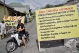 Warga melintasi jalan rusak yang diblokade oleh masyarakat setempat di Desa Condro, Kecamatan Pasirian, Lumajang, Jawa Timur, Kamis (11/7/2024). Aksi blokade jalan menggunakan pohon pisang, mobil pikap, dan ban bekas sejauh 1,2 kilometer tersebut sebagai bentuk protes warga akibat jalan rusak yang tak kunjung diperbaiki selama setahun terakhir.  ANTARA Jatim/Irfan Sumanjaya/mas.