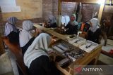 Sejumlah pekerja melinting rokok menggunakan peralatan tradisional di  Rumah Industri Tembakau, kabupaten Aceh Besar, Aceh, Jumat (12/7/2024).  Menurut Asosiasi Petani Tembakau dan industri rokok tradisional di daerah itu, maraknya peredaran rokok impor ilegal  sejak beberapa tahun terakhir dapat mengancam keberlangsung usaha industri tembakau dan diharapkan pemerintah meningkatkan pengawasan dan penindakan tegas terhadap pelakunya. ANTARA FOTO/Ampelsa.