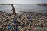 Nelayan berjalan di antara tumpukan sampah plastik saat turun dari perahu yang disandarkan di pinggir pantai Dadap, Juntinyuat, Indramayu, Jawa Barat, Jumat (12/7/2024). Nelayan setempat mengeluhkan banyaknya sampah plastik yang menumpuk di bibir pantai sehingga menghambat aktivitas nelayan saat bersandar dan menurunkan ikan. AANTARA FOTO/Dedhez Anggara/agr