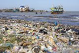 Nelayan turun dari perahu yang tidak bisa bersandar di bibir pantai akibat tumpukan sampah plastik di pantai Dadap, Juntinyuat, Indramayu, Jawa Barat, Jumat (12/7/2024). Nelayan setempat mengeluhkan banyaknya sampah plastik yang menumpuk di bibir pantai sehingga menghambat aktivitas nelayan saat bersandar dan menurunkan ikan. AANTARA FOTO/Dedhez Anggara/agr