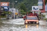 Kendaraan SAR yang membawa korban banjir untuk dievakuasi melewati jalan yang tergenang banjir di Kota Gorontalo, Gorontalo, Kamis (11/7/2024). BPBD Kota Gorontalo mendata sebanyak 1.669 KK atau mencapai 12.487 jiwa terdampak banjir yang menggenangi Kecamatan Kota Selatan, Hulonthalangi, Dumbo Raya, Kota Barat, Kota Timur, dan Dungingi akibat luapan sungai Bulango dan Bone. ANTARA FOTO/Adiwinata Solihin/tom.