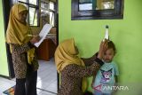 Kader posyandu Kenanga mengukur tinggi badan anak saat posayandu di Desa Utama, Kabupaten Ciamis, Jawa Barat, Sabtu (13/7/2024). Dinas Kesehatan Kabupaten Ciamis dan Pemerintah Desa setempat melakukan pemberian makanan tambahan (PMT) lokal bagi balita dan ibu hamil untuk meningkatkan pemenuhan status gizi guna mencegah stunting dalam memberdayakan masyarakat serta kader posyandu. ANTARA FOTO/Adeng Bustomi/agr