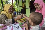 Kader posyandu Kenanga memberikan makanan tambahan (PMT) lokal telur puyuh kepada anak saat posayandu di Desa Utama, Kabupaten Ciamis, Jawa Barat, Sabtu (13/7/2024). Dinas Kesehatan Kabupaten Ciamis dan Pemerintah Desa setempat melakukan pemberian makanan tambahan (PMT) lokal bagi balita dan ibu hamil untuk meningkatkan pemenuhan status gizi guna mencegah stunting dalam memberdayakan masyarakat serta kader posyandu. ANTARA FOTO/Adeng Bustomi/agr